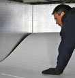 contractor installing TerraBlock™ floor insulation in a Carrollton crawl space