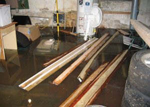 A severely flooding basement in Carrollton, with lumber and personal items floating in a foot of water