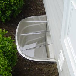 A vinyl basement window and covered window well in Cleburne