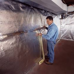 Installation of a radiant heat and vapor barrier on a basement wall in Grapevine