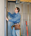 Insulated basement wall panels being placed against a concrete foundation wall in Grand Prairie